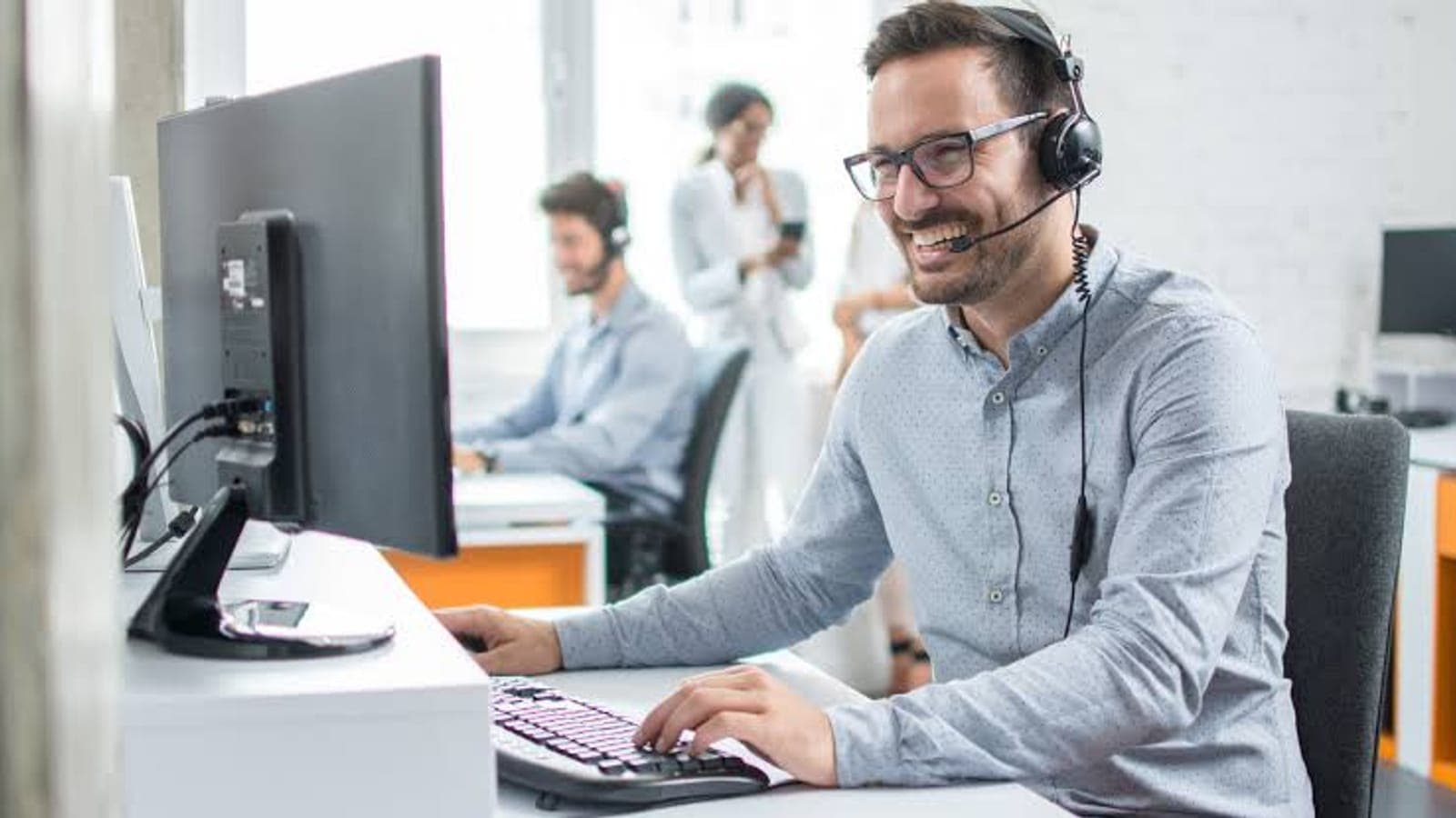 IT helpdesk team answering support requests at their desks