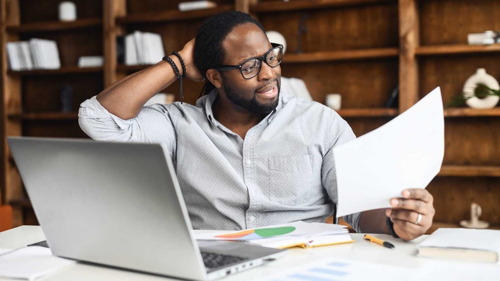 Office worker looking puzzled at a document, representing a common IT support query