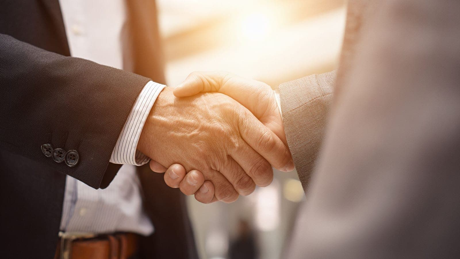 Two businessmen shaking hands on an IT services partnership in Saudi Arabia